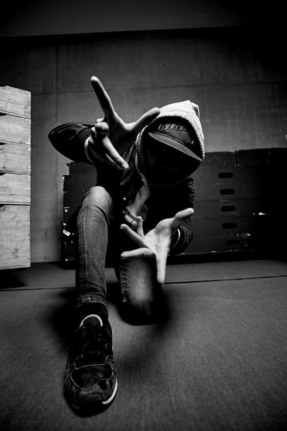 "Danseur en mouvement capturé en noir et blanc dans une pose dynamique au sol."